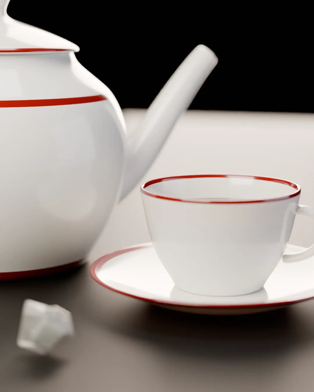 Nahaufnahme: weiße Teetasse mit rotem Rand auf der Untertasse, dahinter unscharf die Teekanne, vorn Kandis